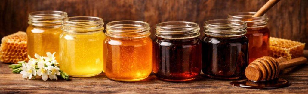 Different types of honey showing colour variation from light to dark.